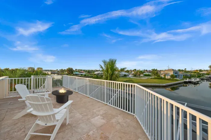 Spacious waterfront terrace with fire table and sweeping canal views