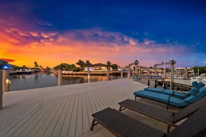 Spacious waterfront deck with lounge chairs and stunning sunset canal views