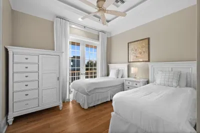 Bright twin bedroom with balcony access and elegant coastal style