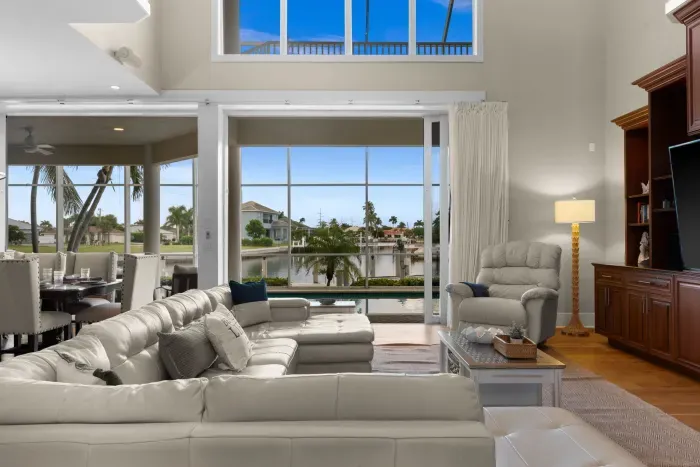 Bright waterfront living room with soaring ceilings and panoramic views