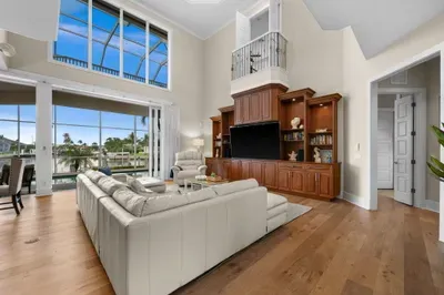 Stunning waterfront great room with soaring ceilings and panoramic views