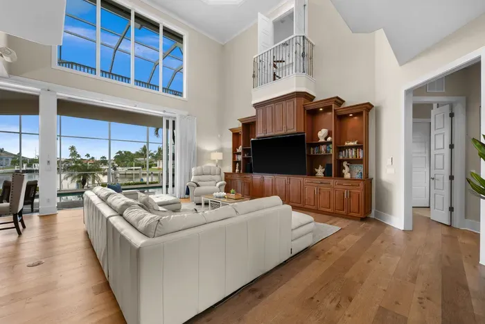 Stunning waterfront great room with soaring ceilings and panoramic views