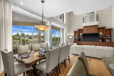 Bright waterfront living space with soaring ceilings and elegant dining area