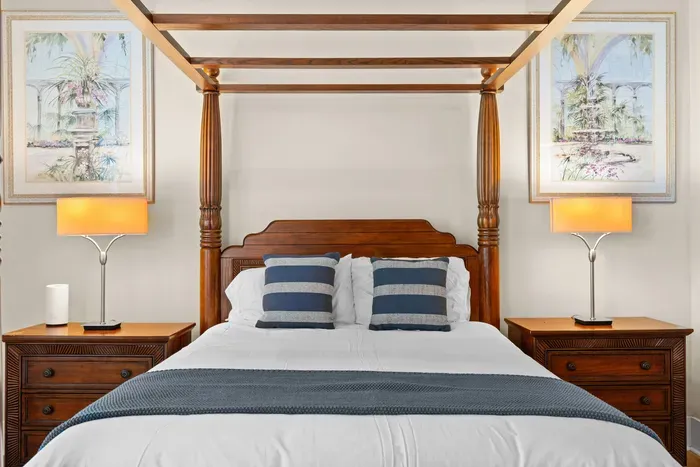 Elegant four-poster bedroom with warm lighting and tropical-inspired decor