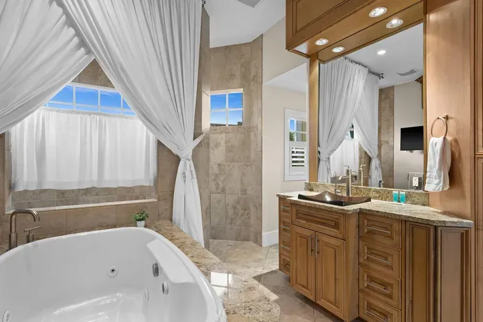 Spa-style bathroom with jetted tub, walk-in shower, and elegant finishes