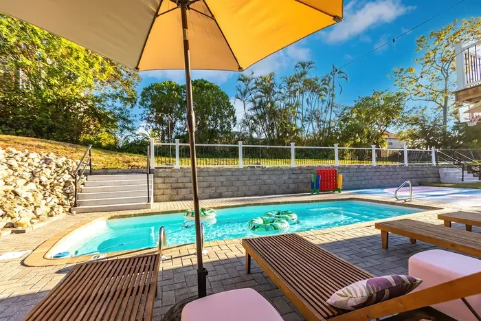 Poolside Oasis: Dive into relaxation with colorful floats and stunning green views!