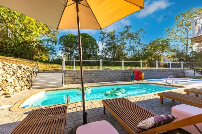 Poolside Oasis: Dive into relaxation with colorful floats and stunning green views!