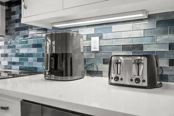 Kitchen: Modern appliances and a stylish blue backsplash invite culinary adventures!