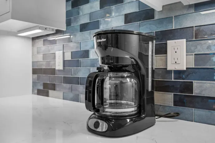 Kitchen: Brew your perfect cup with stylish convenience against a gorgeous blue tile backdrop!