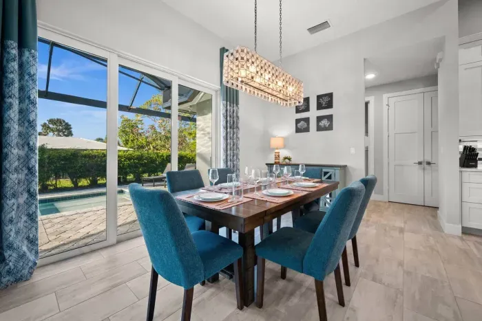 Dining Room: Elegant table set for gatherings, with natural light and poolside views. Perfect for memories!