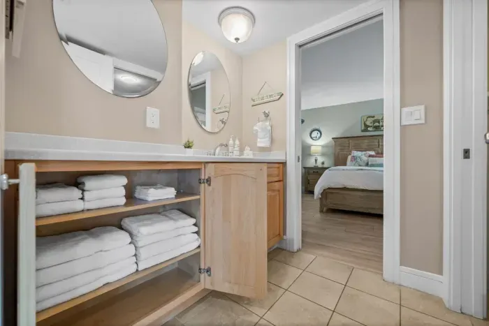 Bathroom Oasis: Bright space with plush towels, dual mirrors, and fresh decor for a relaxing retreat!