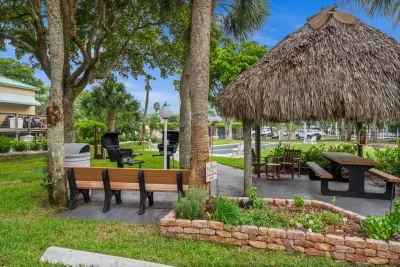 Outdoor Oasis: Enjoy grilling and lounging under the tiki hut in this tropical paradise!
