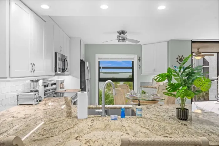 Kitchen: Bright granite countertops and coastal views make cooking a joy!