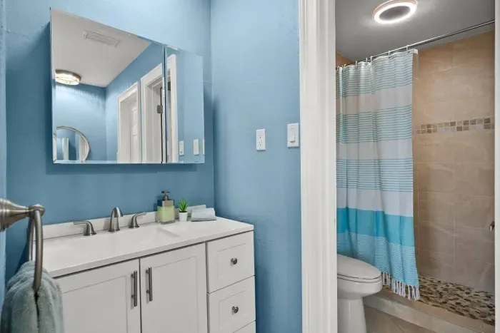 Bathroom Bliss: Bright blue walls and modern fixtures for a refreshing retreat after beach days!