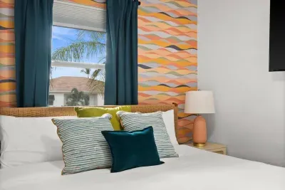 Bright Retreat: Vibrant décor, plush pillows, and palm views beckon you to unwind in bliss!
