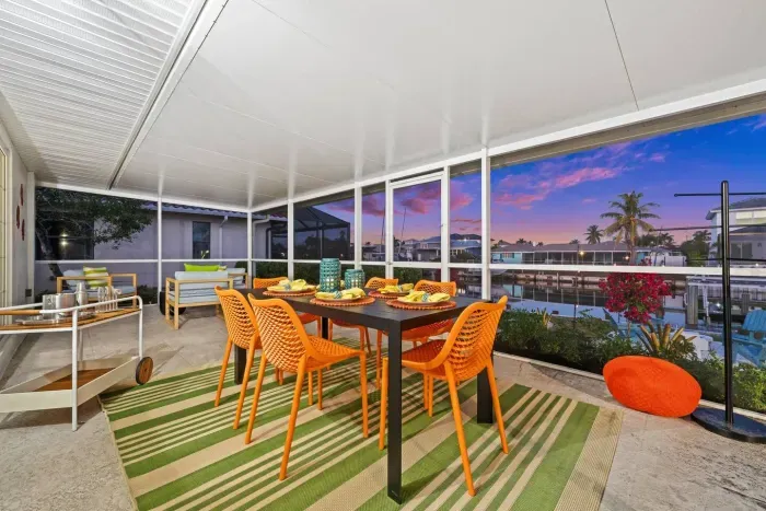 Screened Patio: Dine al fresco with vibrant décor and stunning water views at sunset!