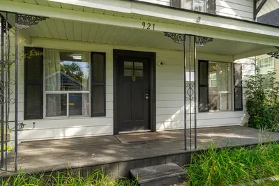 Charming covered front porch with classic shutters and welcoming entry