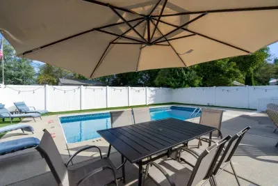 Private fenced pool with shaded patio dining and lounge chairs