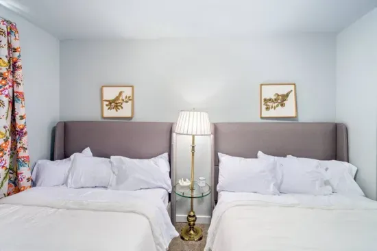 Two full size beds, Serta pillow-top mattresses, night stand with lamp, charging cable for phones, jewelry dish, blackout curtains, 2 luggage racks