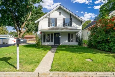 Charming two-story home with a covered porch and spacious front lawn
