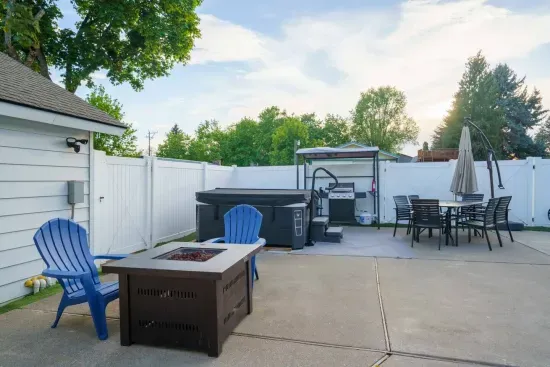 Fire pit table with four Adirondack chairs. Propane grill