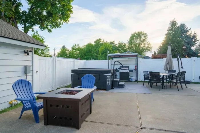 Fire pit table with four Adirondack chairs. Propane grill