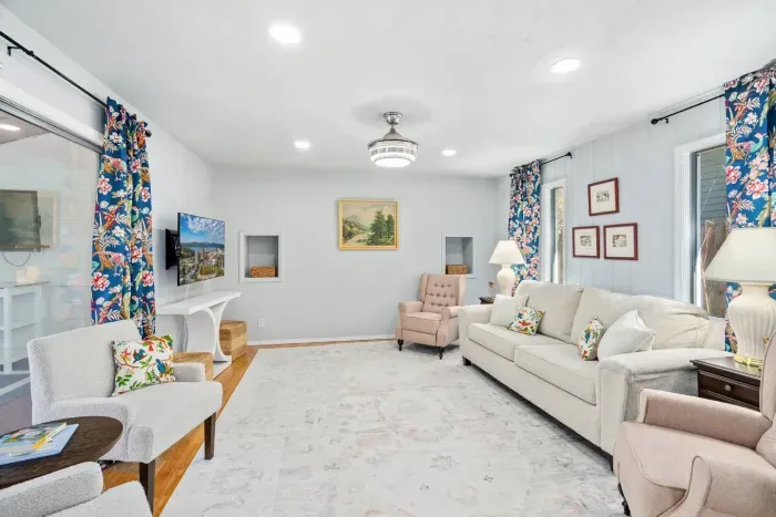 Pull-out couch with queen size mattress, two wing-back recliners, two arm chairs, 55" Smart TV, ceiling fan