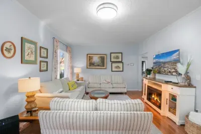 Cozy, light-filled living room with fireplace, TV, and plenty of seating