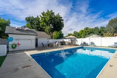 Private backyard pool with loungers and shaded outdoor seating