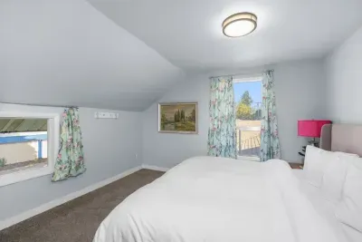 Bright, cozy bedroom with plush bedding, natural light, and charming details