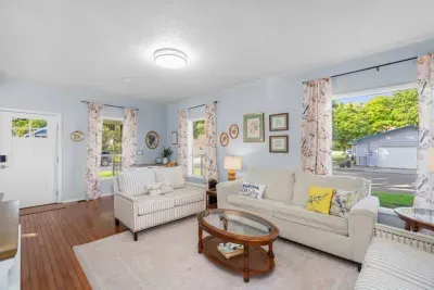 Bright, cozy living room with large windows and charming cottage style