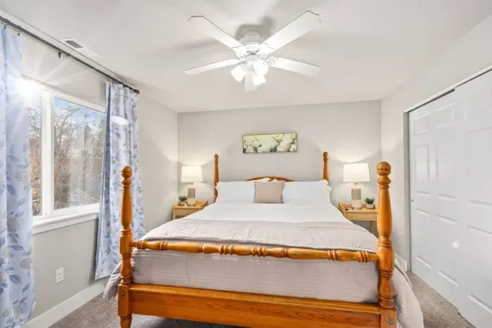 BEDROOM 1: King size bed, nightstands with storage, dresser, lamps, room-darkening curtains, phone charging cable, luggage rack, ceiling fan, clothes hangers, laundry hamper.