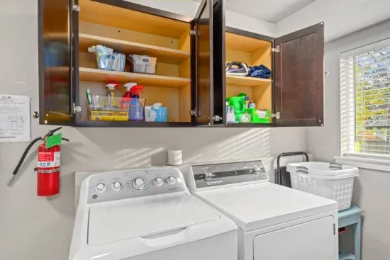 LAUNDRY ROOM: Full washer and dryer, detergent, supplies, iron, ironing board, Dyson cordless vacuum, and extra linens.
