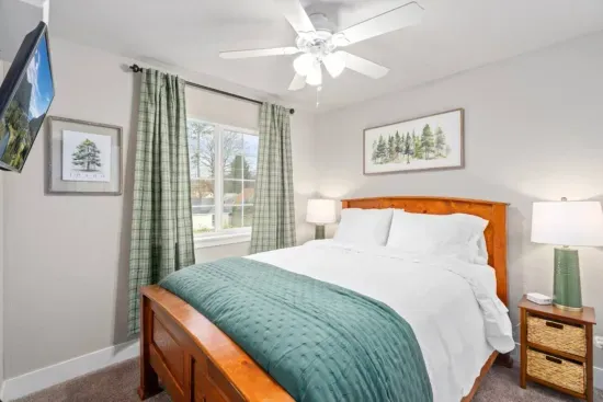 BEDROOM 2: Queen size bed, nightstands, lamps, blackout curtains, phone charging cable, luggage rack, ceiling fan, clothes hangers, laundry hamper.