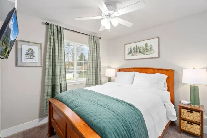 BEDROOM 2: Queen size bed, nightstands, lamps, blackout curtains, phone charging cable, luggage rack, ceiling fan, clothes hangers, laundry hamper.