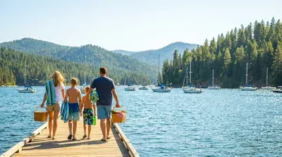 Family with picnic baskets walks on Coeur d'Alene dock