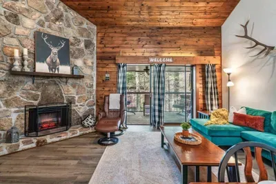 Open concept family room with electric fireplace, large TV  and access to balcony.