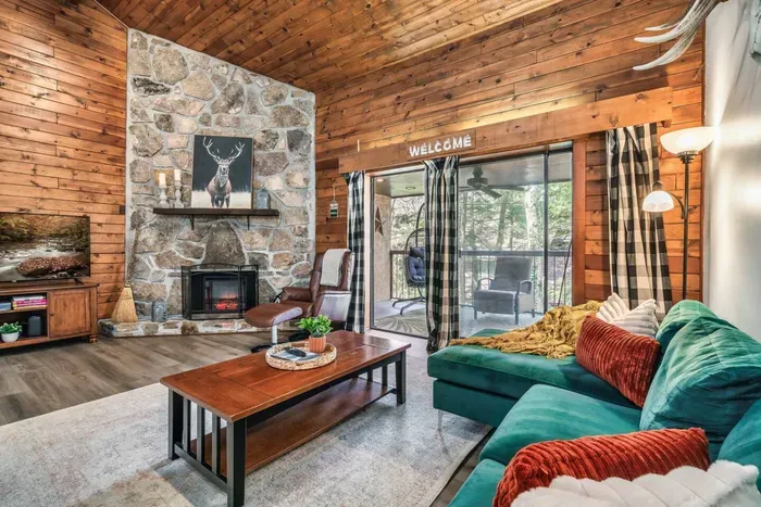 Open concept family room with electric fireplace, large TV  and access to balcony.