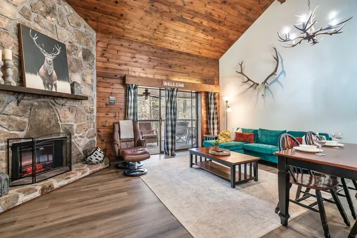 Open concept family room with electric fireplace, large TV  and access to balcony.