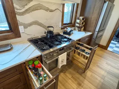 Convenient pullout drawers designed for storing spatulas, spoons, and spices maximizing organization and accessibility.