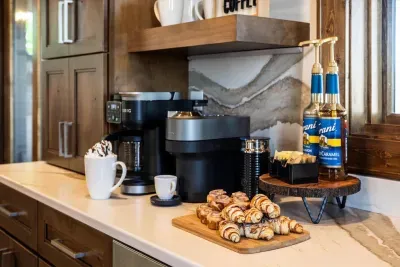 This kitchen is a coffee lover's dream featuring both a Keurig coffee maker with pot, and a Nespresso machine, alongside a french press to cater to all your caffeine cravings.
