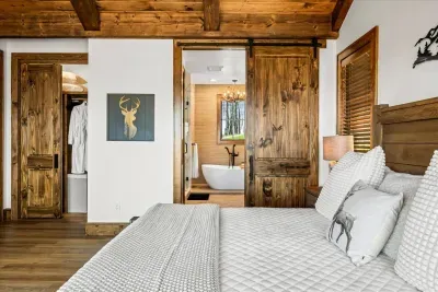 This primary bedroom boats a stunning en suite bathroom accessible through an elegant barn door, adding a touch of rustic charm to the space.