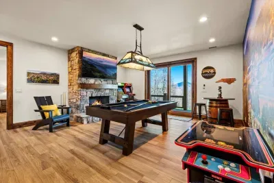 A game room perfect for families and friends, featuring a pool table, video games, gas fireplace, 75" Smart TV, and more!