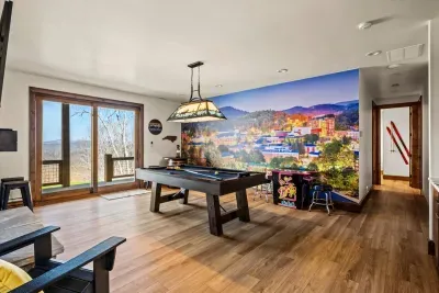 An App State themed game room that includes a gorgeous mural of the campus, a pool table and video games.