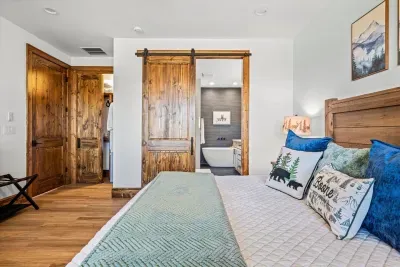 This primary bedroom boats a stunning en suite bathroom accessible through an elegant barn door, adding a touch of rustic charm to the space.