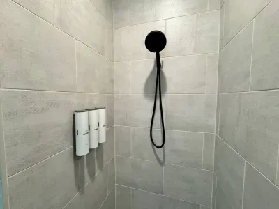 The walk-in shower features floor-to-ceiling tile and all the necessary amenities – shampoo, conditioner, and body wash – for a luxurious experience.