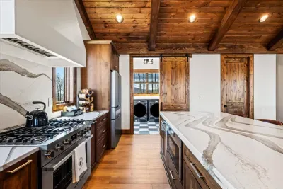 The centerpiece is a large, luxurious island perfect for meal prep or casual dining.  Surrounding the island, custom cabinetry offers abundant storage, with soft-close drawers.