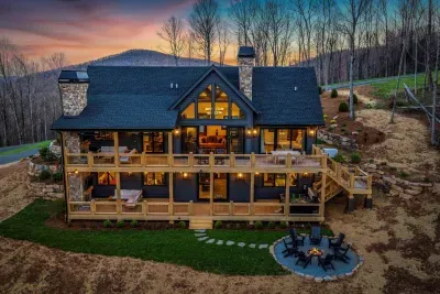 A spacious two-level deck spanning the entire length of the house, offering long-range, unobstructed mountain views. Two outdoor fireplaces, a hot tub, two sectional couches, rocking chairs, a dining table and a back yard fire pit.