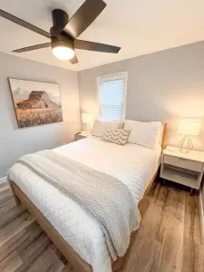 Bedroom 2 is on the main floor and includes a queen size bed, a dresser, closet, 2 nightstands with USB/plug outlets, and a 55" Roku Smart TV.