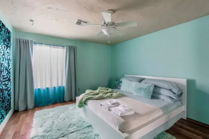 Luxurious shag carpet and shimmering sequin wall art make the Aqua Room with King size bed a primo place to unwind.